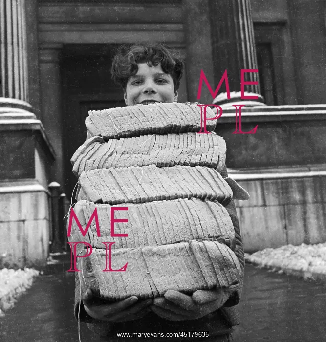: Bread Boy. A smiling young boy carries an armful of sliced loaves of bread : Bread Boy. A smiling young boy carries an armful of sliced loaves of bread