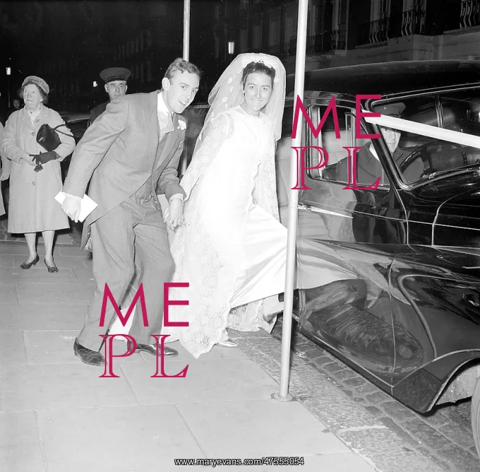 : The bride and groom getting into a car : The bride and groom getting into a car