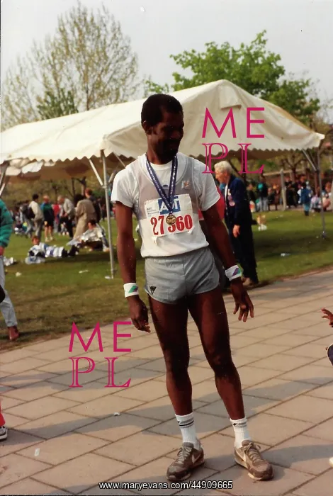 : British Caribbean marathon runner standing with medal : British Caribbean marathon runner standing with medal