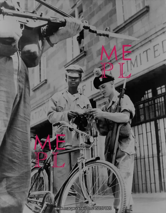 : British soldiers examining papers of an African : British soldiers examining papers of an African
