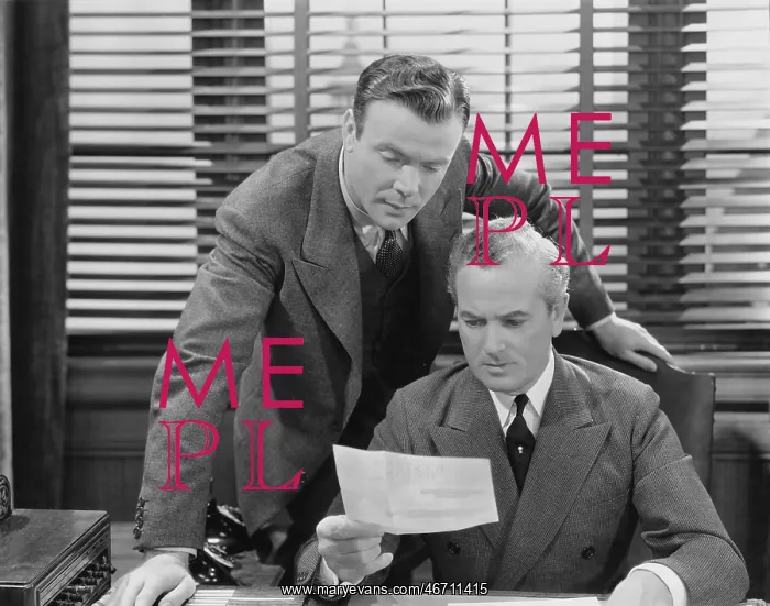 : Two businessmen with an inter office memo : Two businessmen with an inter office memo