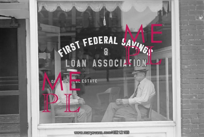: Two businessmen sit behind the storefront ? : Two businessmen sit behind the storefront ?