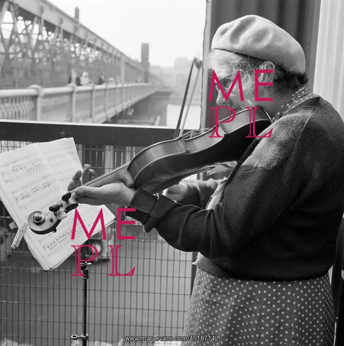 : Busker. An informal portrait of a woman busker playing the violin : Busker. An informal portrait of a woman busker playing the violin