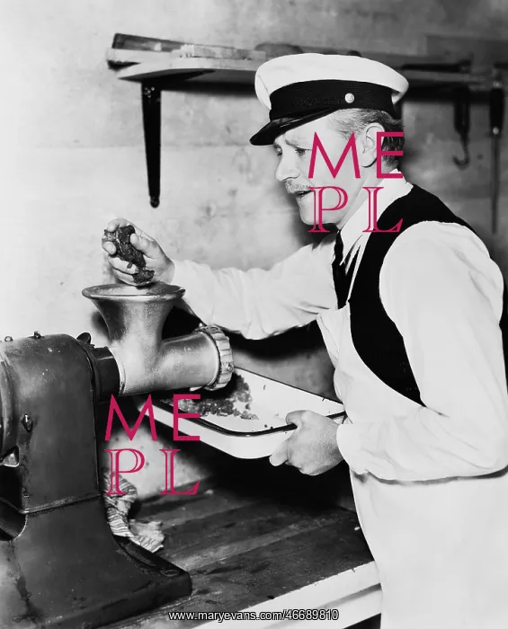 : Butcher grinding meat : Butcher grinding meat