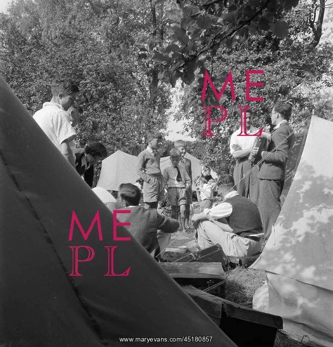 : Camping. Looking through the space between two tents towards a group of people camping : Camping. Looking through the space between two tents towards a group of people camping