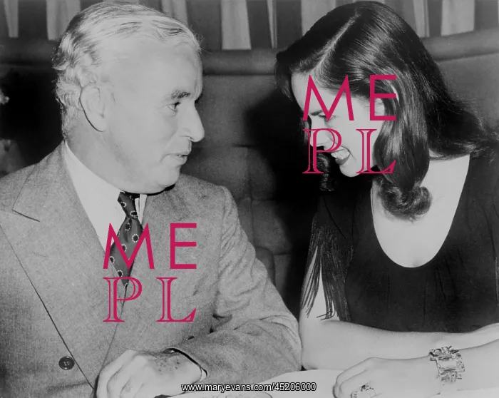 : Charlie Chaplin (1889-1977) sitting with ? : Charlie Chaplin (1889-1977) sitting with ?