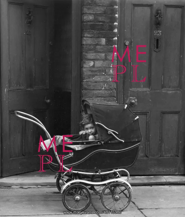 : Child in a pram outside a house : Child in a pram outside a house