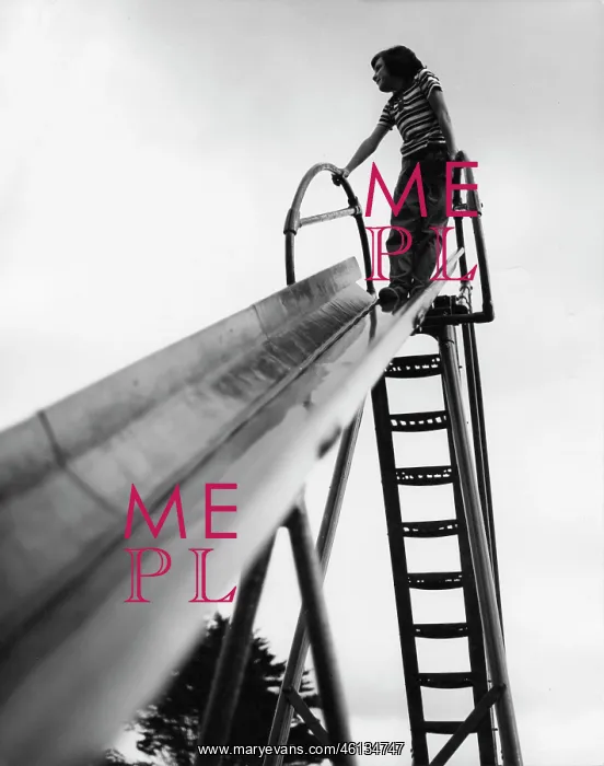 : Child standing at the top of a playground slide : Child standing at the top of a playground slide
