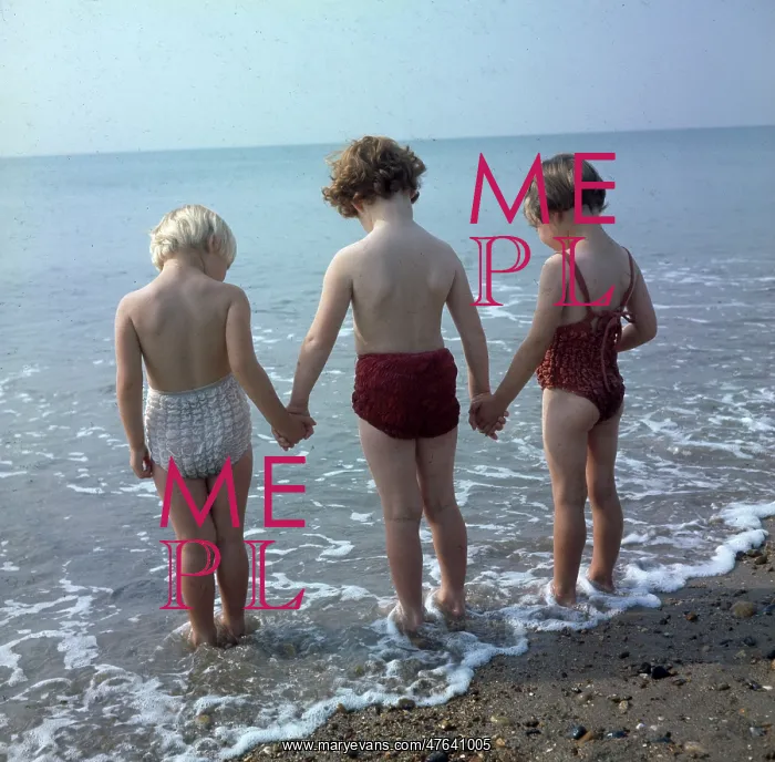  : Three children holding hands, paddling in the sea