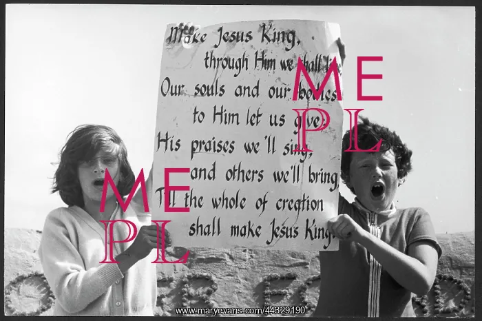 : Children holding up hymn lyrics on a beach : Children holding up hymn lyrics on a beach
