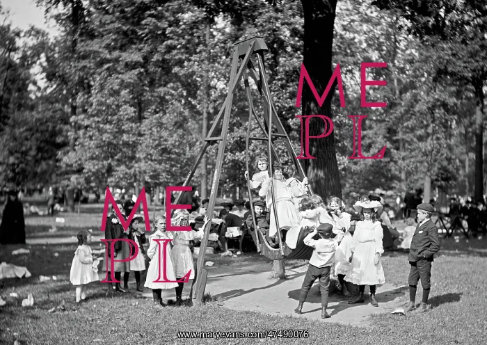: Children playing on the swings in a park playground in Ameri : Children playing on the swings in a park playground in Ameri