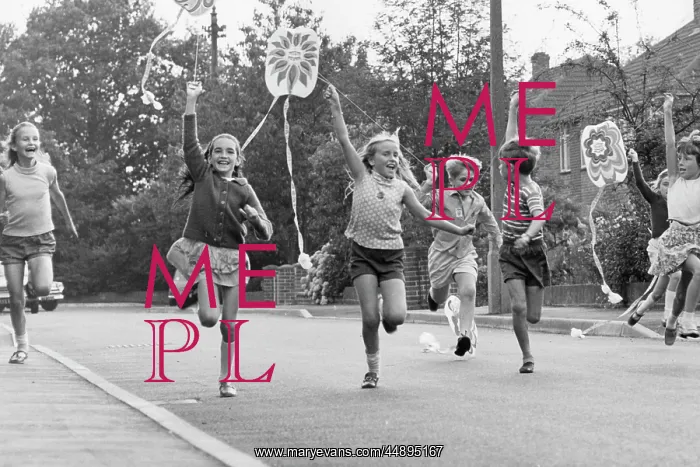 : Children running along a street with their kites : Children running along a street with their kites