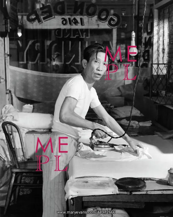 : Chinese Laundry Man Looking at Camera Ironing Clothes on B : Chinese Laundry Man Looking at Camera Ironing Clothes on B