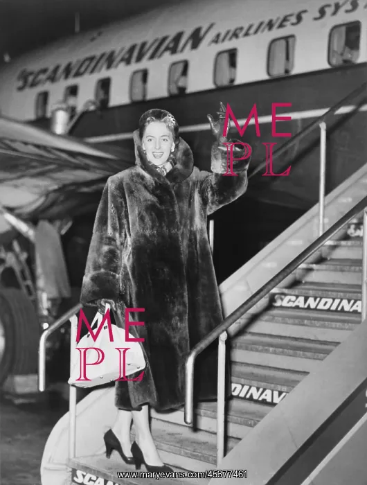 : Christine Jorgensen, waves as she boards an : Christine Jorgensen, waves as she boards an