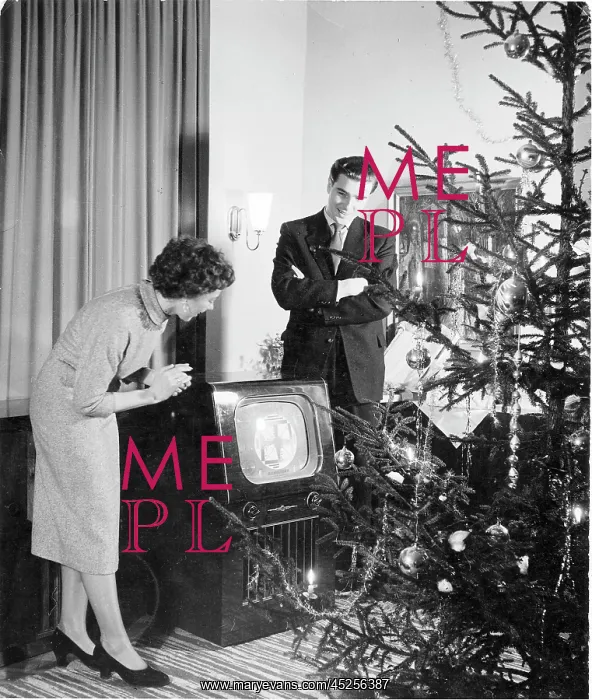 : Christmas. A young couple looks at the new television on Christmas Evening : Christmas. A young couple looks at the new television on Christmas Evening