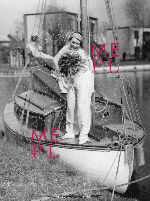 : Cleaning. A woman is cleaning the deck of her yacht. Photograph. Wrexham. 1935 : Cleaning. A woman is cleaning the deck of her yacht. Photograph. Wrexham. 1935