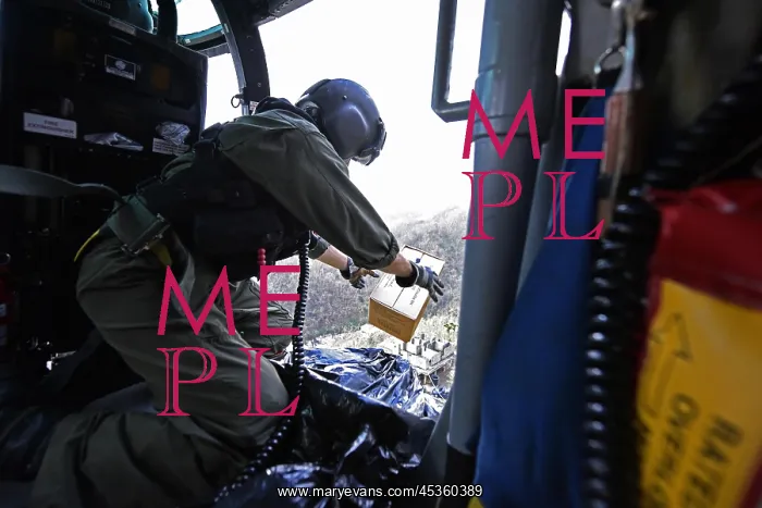 : US Coast Guard helicopter drops a box of MREs to : US Coast Guard helicopter drops a box of MREs to