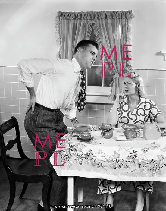 : Couple at Breakfast Table Man with Hand on Hip Suffering B : Couple at Breakfast Table Man with Hand on Hip Suffering B