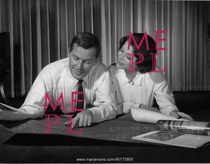 : Couple indoors looking at blueprints : Couple indoors looking at blueprints