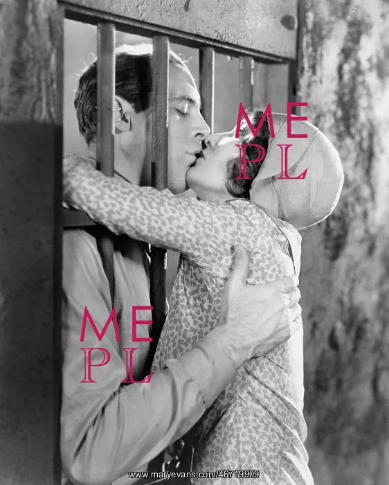 : Couple kissing through bars of jail cell : Couple kissing through bars of jail cell