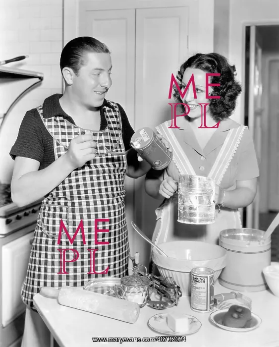: Couple together in the kitchen baking a cake : Couple together in the kitchen baking a cake