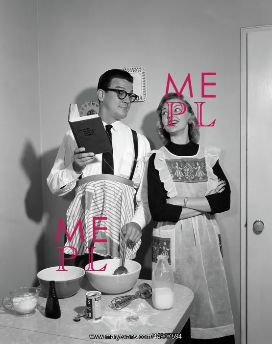 : Couple in kitchen with husband learning to cook : Couple in kitchen with husband learning to cook