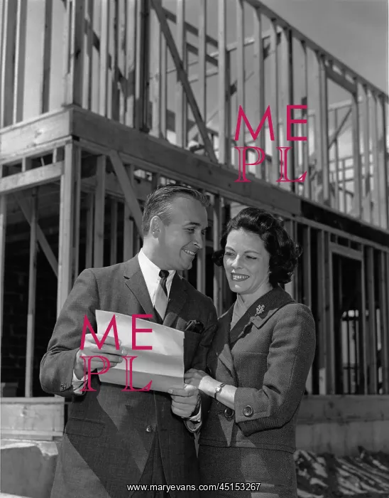 : Couple looking at paperwork in front of their new house : Couple looking at paperwork in front of their new house