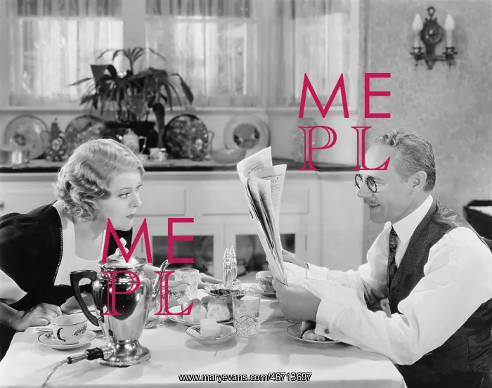: Couple reading newspaper at breakfast table : Couple reading newspaper at breakfast table