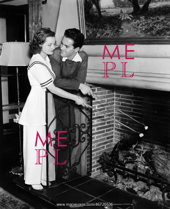 : Couple roasting marshmallows over fireplace : Couple roasting marshmallows over fireplace