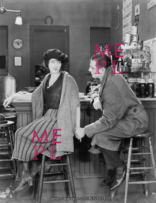 : Couple sitting together at a bar looking at each other : Couple sitting together at a bar looking at each other