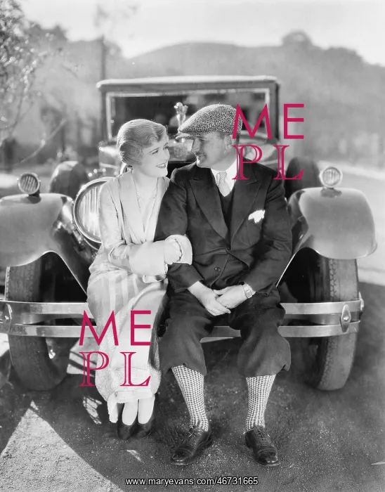 : Couple sitting together on a car bumper : Couple sitting together on a car bumper