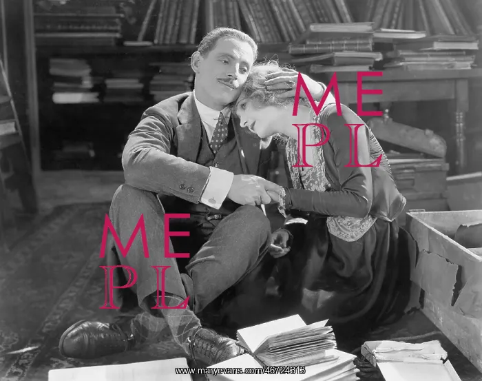 : Couple sitting on the floor of a library holding each other : Couple sitting on the floor of a library holding each other