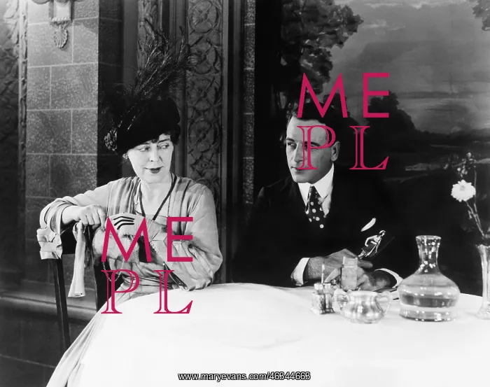 : Couple sitting at a table in a restaurant looking : Couple sitting at a table in a restaurant looking