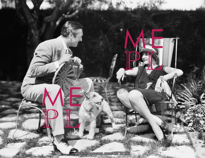 : Couple sitting in the back yard talking with a dog : Couple sitting in the back yard talking with a dog