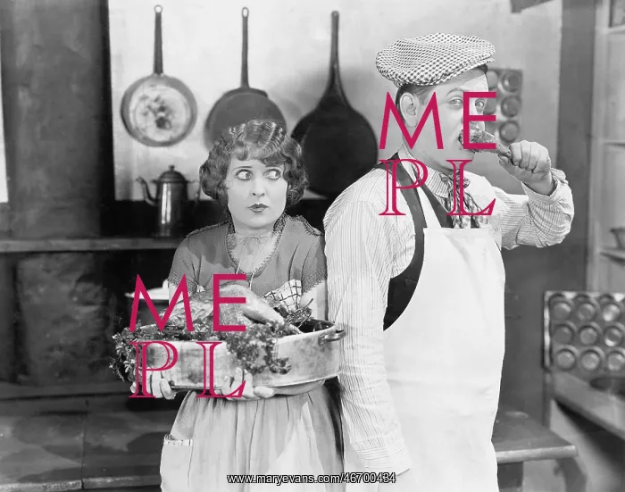 : Couple standing together in a kitchen with a cooked turkey : Couple standing together in a kitchen with a cooked turkey