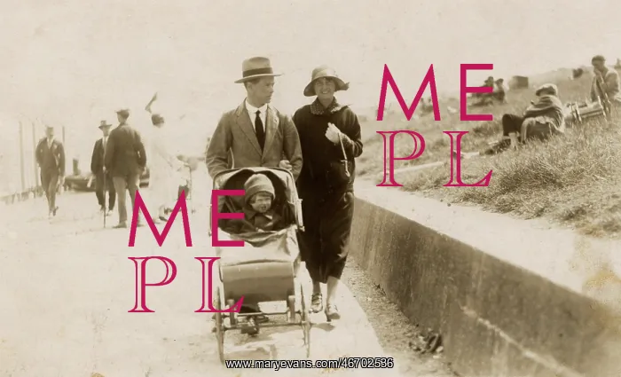 : Couple strolling along the seafront with toddler in buggy : Couple strolling along the seafront with toddler in buggy