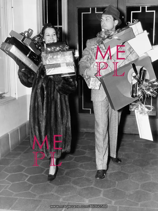 : Couple walking and holding stacks of presents : Couple walking and holding stacks of presents