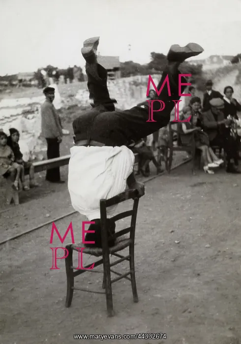 : Creative. A Young Greek in a folklore dance pose with chairs, in Laurion : Creative. A Young Greek in a folklore dance pose with chairs, in Laurion