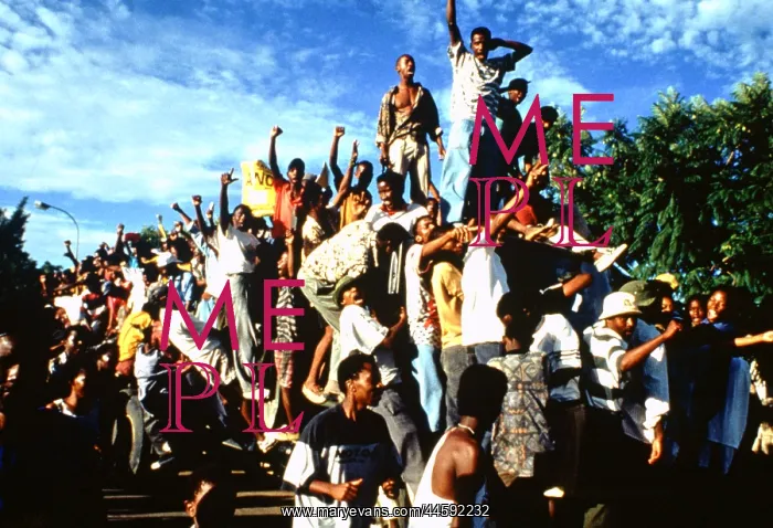 : Crowds swarm over a bus, fists raised in protest : Crowds swarm over a bus, fists raised in protest