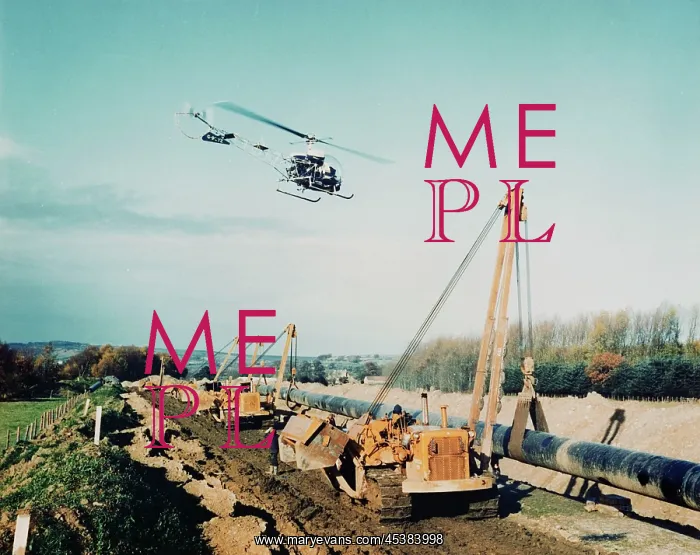 : Cumbria. A helicopter flying over a row of Caterpillar pipelayers during : Cumbria. A helicopter flying over a row of Caterpillar pipelayers during