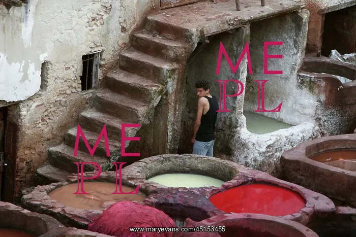 : Fez. Detail of dyeing pits with a young boy in the background by the stone stairway : Fez. Detail of dyeing pits with a young boy in the background by the stone stairway