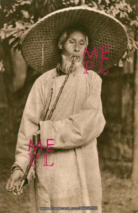 : Elderly Chinese man in hat smoking a long pipe : Elderly Chinese man in hat smoking a long pipe