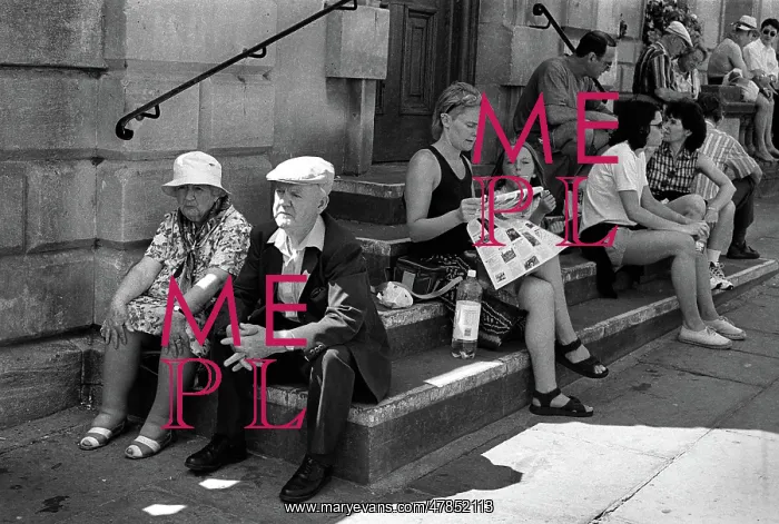 : An elderly couple sitting on steps outside Bath Abbey : An elderly couple sitting on steps outside Bath Abbey