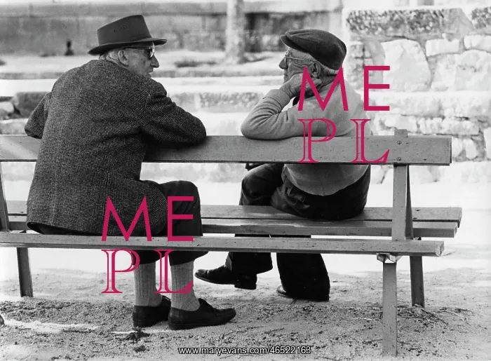 : Two elderly men chatting on a bench : Two elderly men chatting on a bench