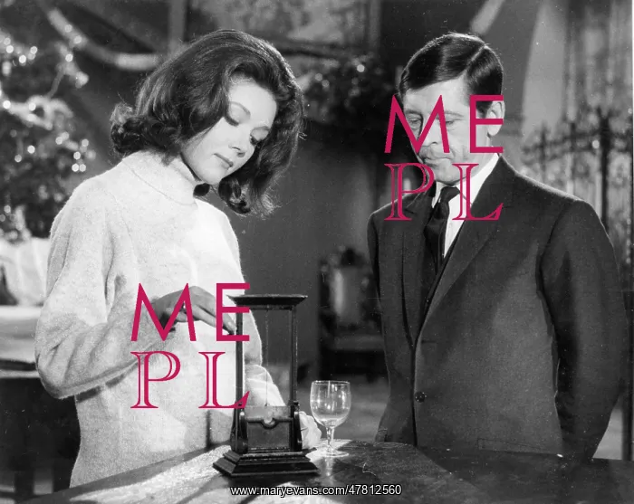 : Emma Peel discussing a model guillotine with a protagonist : Emma Peel discussing a model guillotine with a protagonist