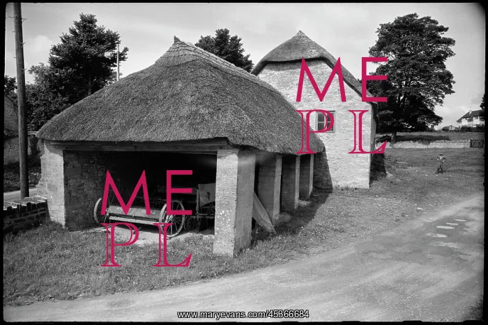 : Exterior view of a single-storey thatched barn : Exterior view of a single-storey thatched barn