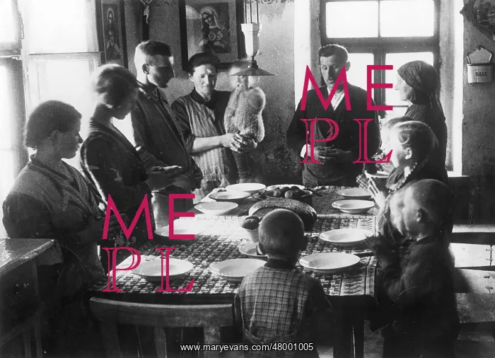 : Family gathers around a table and says grace : Family gathers around a table and says grace