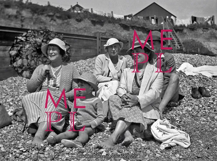 : Family group on a pebbly beach at the seaside : Family group on a pebbly beach at the seaside