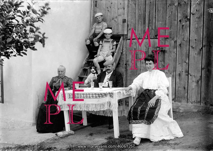: A Family Sitting at a Table : A Family Sitting at a Table
