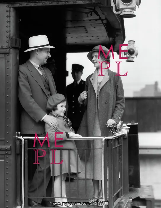 : Family of three standing at railing at back of : Family of three standing at railing at back of